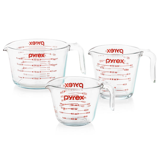 Three Pyrex measuring cups on a white background